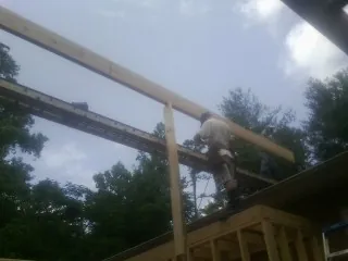 Carpenter setting a ridge beam over a new addition frame — Ice Dam Removal by Roofing Brothers in Southmont