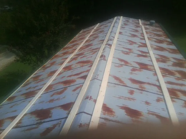 Rusted metal roof panels with new wood purlins before replacement — Storm Damage Roof Repair in Southmont by Roofing Brothers