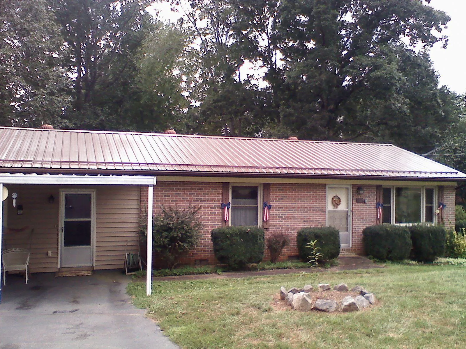 Bronze metal roof and carport on a brick ranch home — Roof Repair work by our crew in Southmont